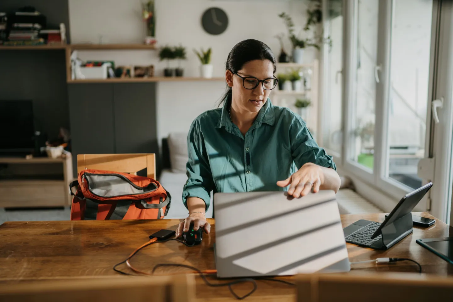 A woman sitting at a desk closes her laptop.