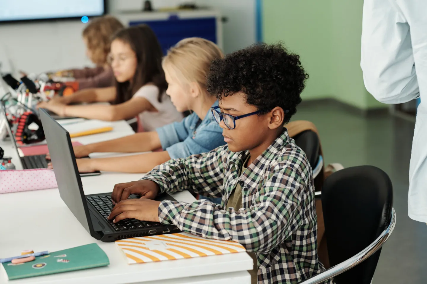 Students work at laptops in a classroom