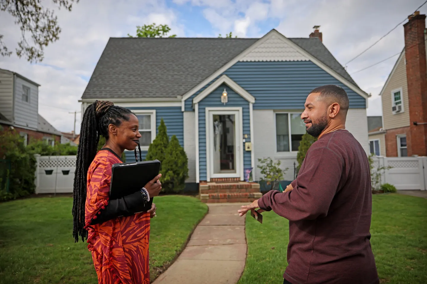 Real estate broker Susan Chen speaks with potential home buyer Hector Camacho outside of a open house in Valley Stream, New York, on May 4, 2023.