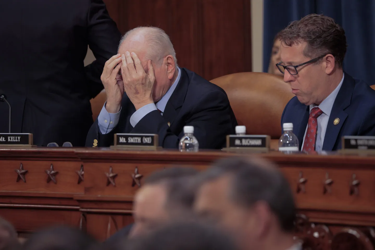 House Ways and Means Committee member Rep. Mike Kelly (R-PA) covers his face with his hands as Rep. Adrian Smith (R-NE) sits next to him at a markup hearing in the Longworth House Building on Capitol Hill on May 13, 2025 in Washington, DC.