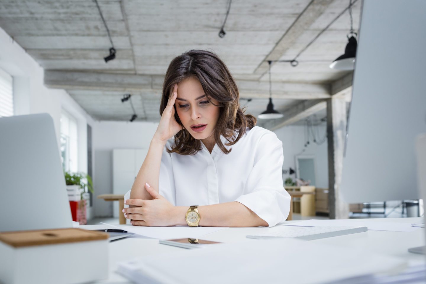 woman sitting at desk stressed