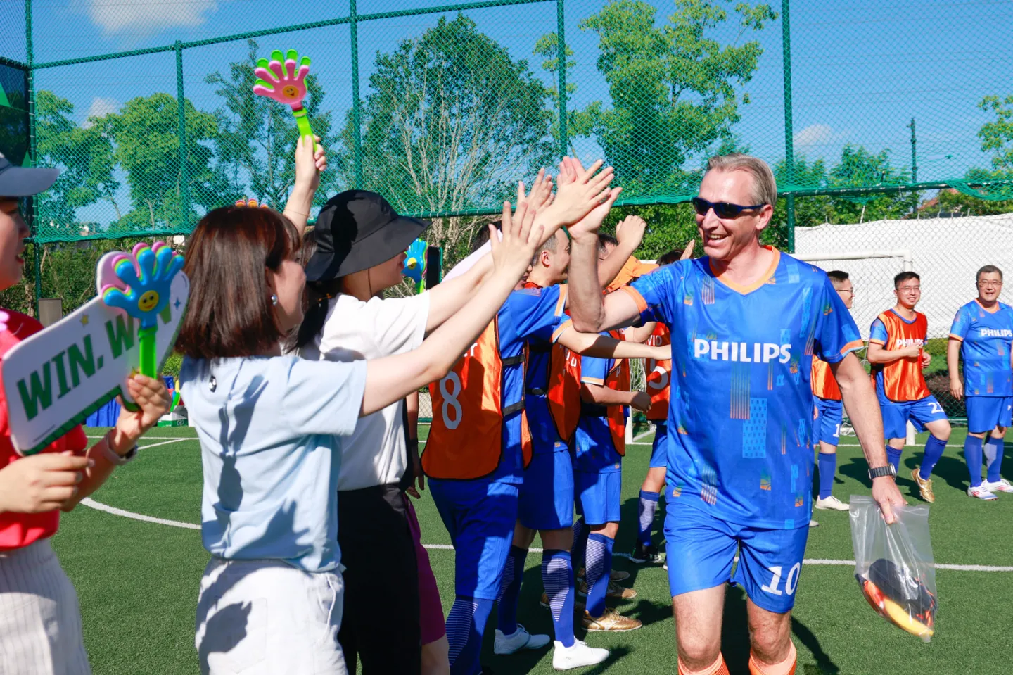 man with sunglasses high-fiving people